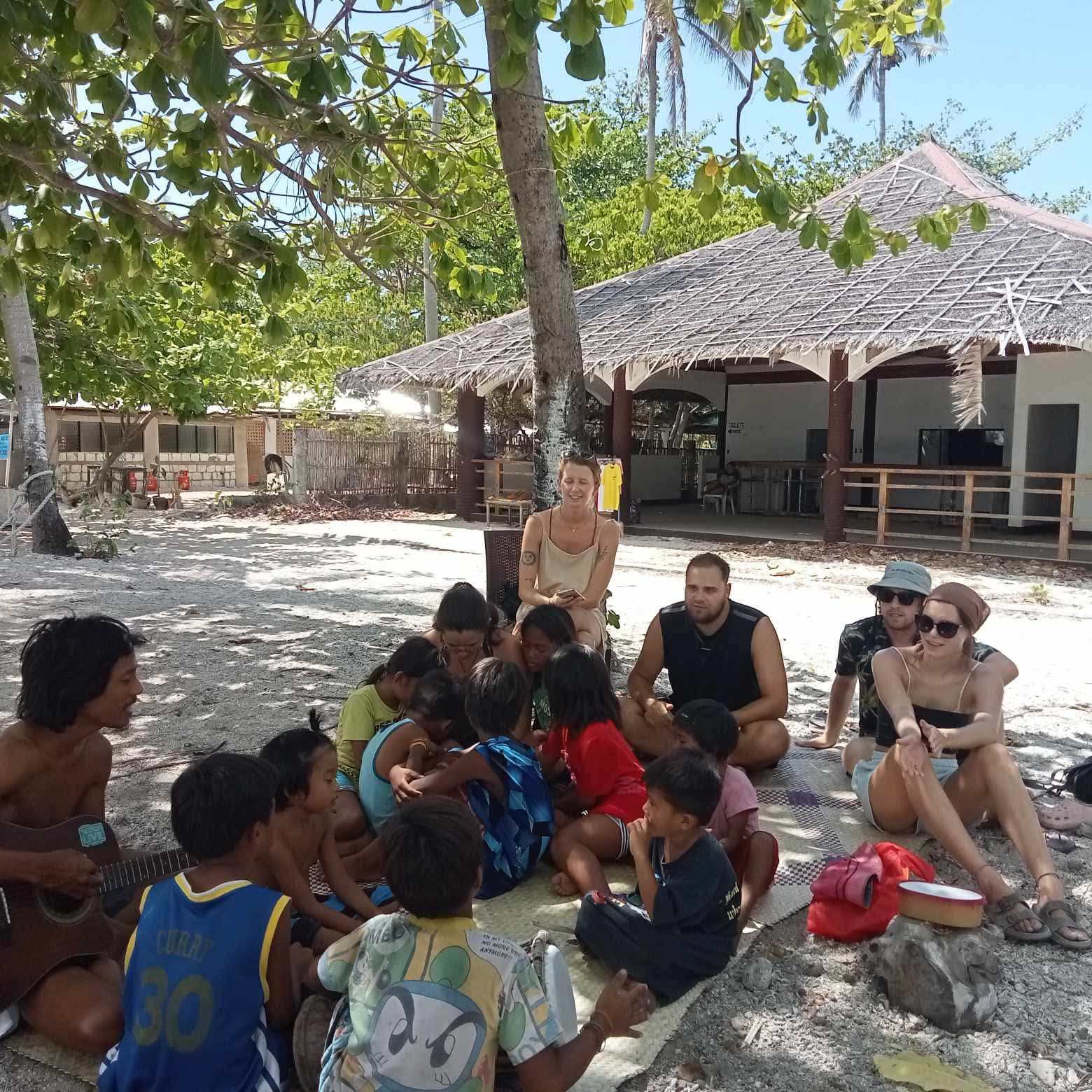 Group gathering in a circle on the beach with local island community